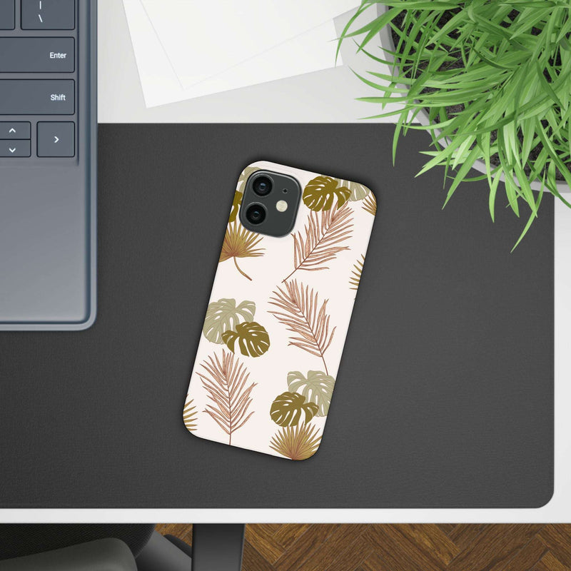 Nature-inspired mobile phone case with tropical leaf design on desk.