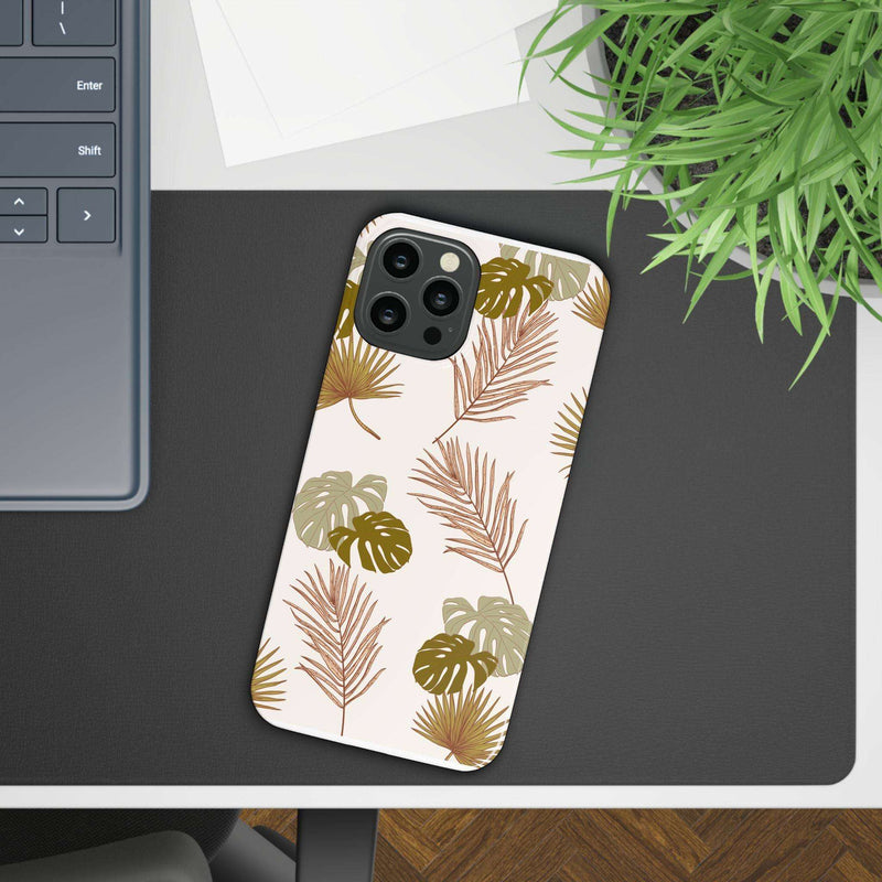 Nature-inspired mobile phone case with tropical leaf design on desk. Slim, durable, and stylish protection. Compatible with iPhone 16 series.