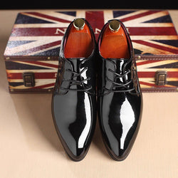 Men's black leather formal shoes with shiny finish, ideal for business attire, displayed on a wooden surface.